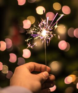 bokeh photography of person holding fireworks