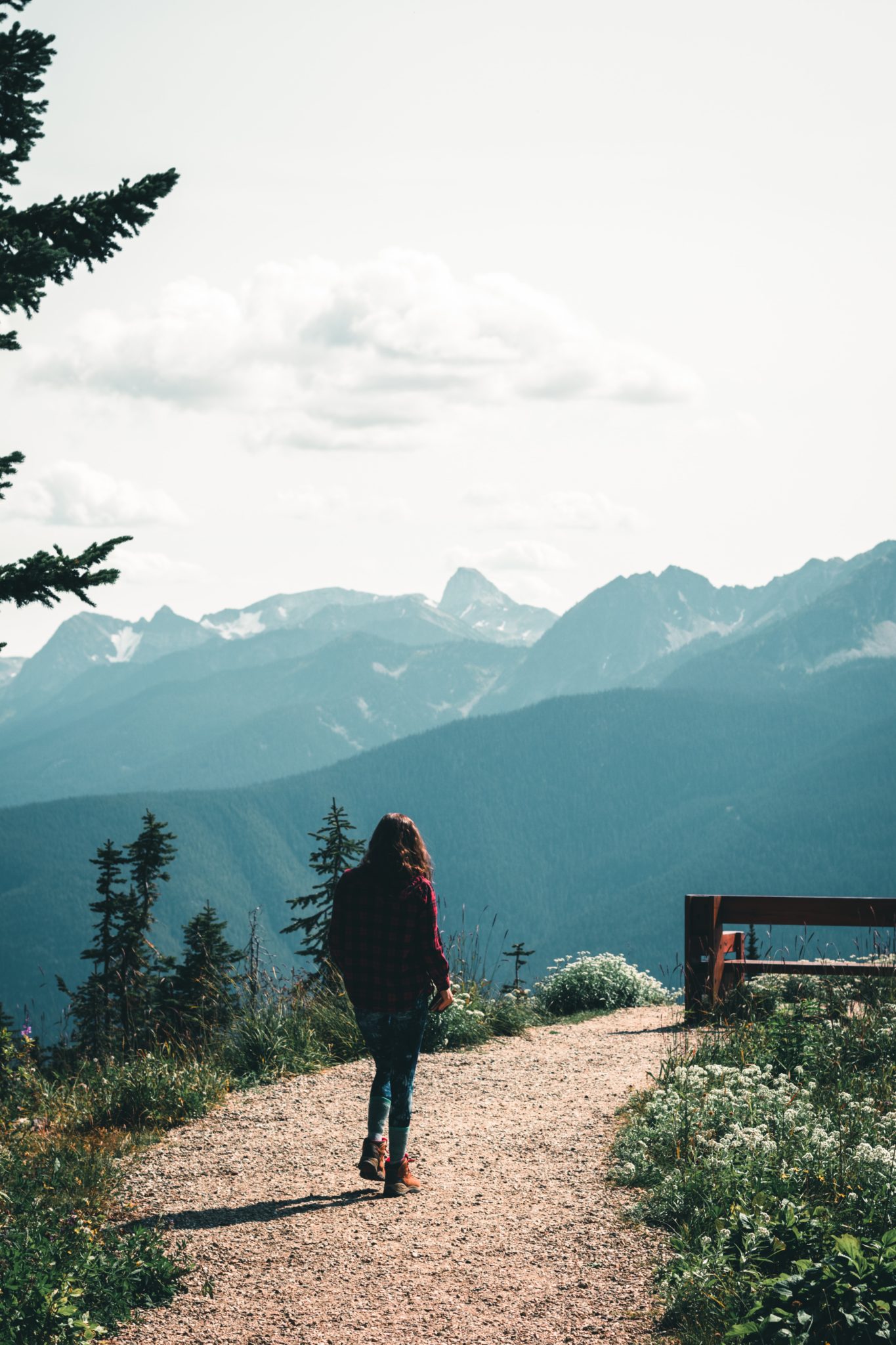 woman in black jacket standing on brown wooden fence during daytime