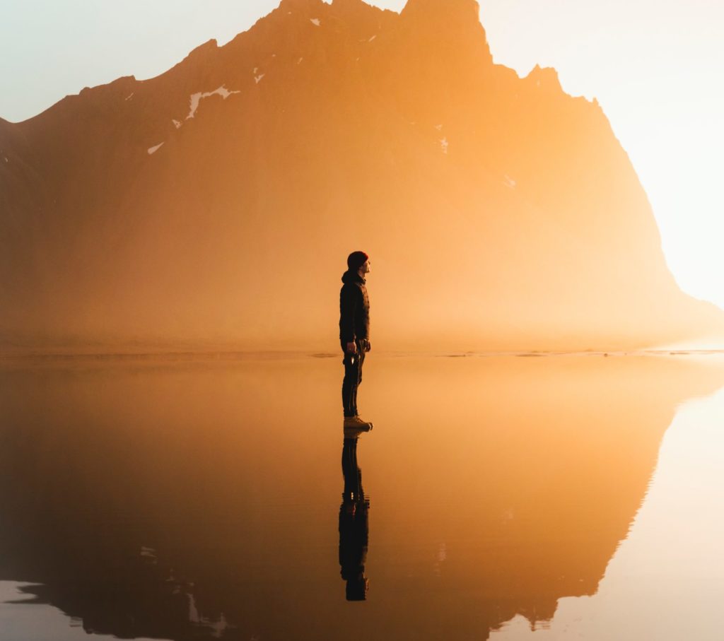 silhouette of woman standing on water during daytime