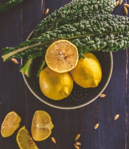 sliced lemon and green leaves on gray stainless steel bowl