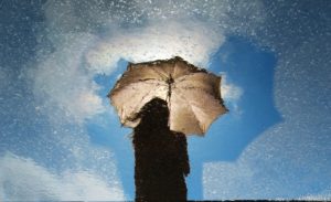 person standing on gray surface while holding umbrella