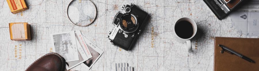 camera, pair of brown shoes, white ceramic mug, grey and black pen, brown smoking pipe