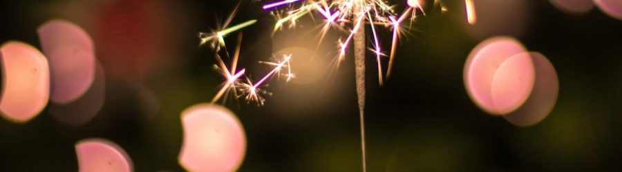 bokeh photography of person holding fireworks